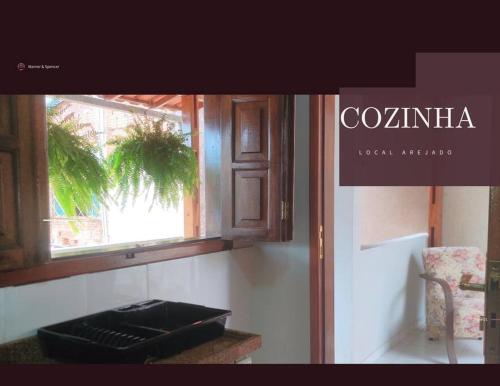 eine Küche mit einem Fenster und einer Arbeitsplatte mit einem Aasser in der Unterkunft Eletric Car Flat in Teófilo Otoni