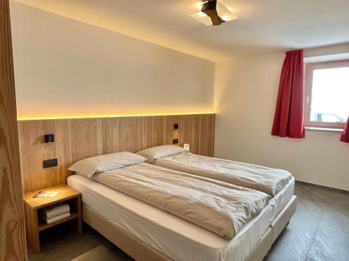 um quarto com uma cama grande e uma cortina vermelha em Appartamenti Mauro em Livigno