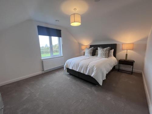 a white bedroom with a large bed and a window at Modern Dunboyne Home in Dunboyne