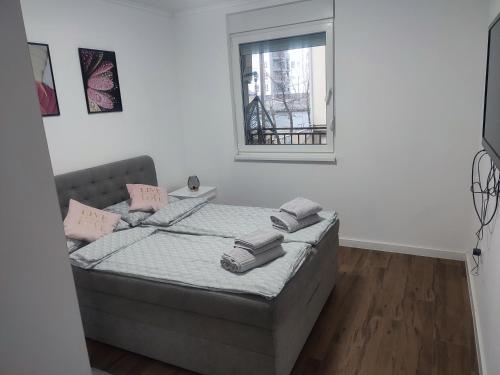 a bedroom with a bed with two pillows on it at Novak apartman in Subotica