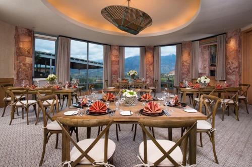 a dining room with tables and chairs and windows at Garden of the Gods Resort & Club in Colorado Springs