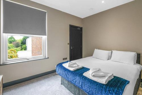 a bedroom with a large bed with towels on it at Wiverton Apt #3 - Central Location - Free Parking, Fast WiFi and Smart TV by Yoko Property in Nottingham