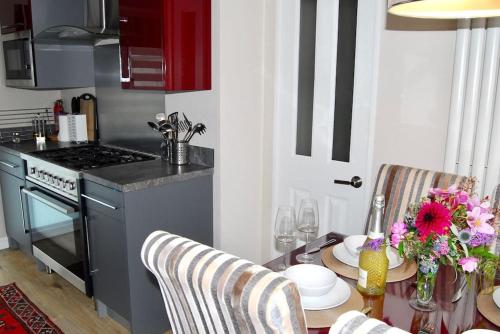 a kitchen with a table with chairs and a table sidx sidx sidx at Birch Tree Lodge 96 Main park in Jedburgh