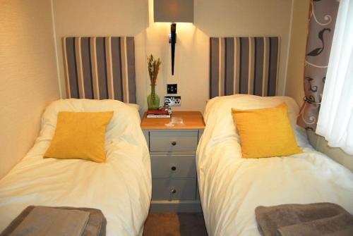 two beds sitting next to each other in a bedroom at Birch Tree Lodge 96 Main park in Jedburgh