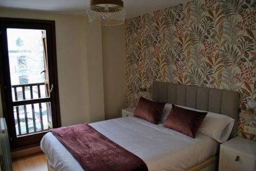 エスカリリャにあるLa Casa de la Montañaの白いシーツと窓のあるベッドのある寝室