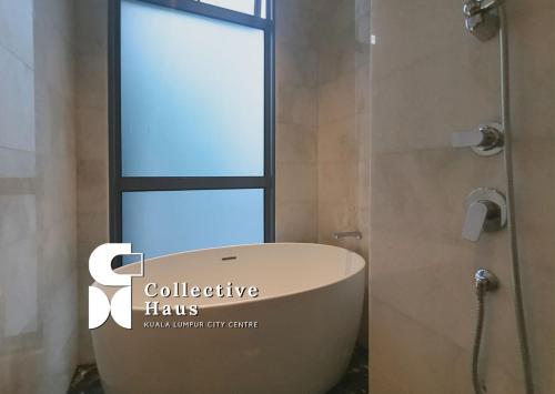 bagno con vasca e finestra di Royce Residence Kuala Lumpur by Collective Haus a Kuala Lumpur