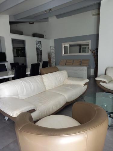 a living room with a white couch and chairs at La Ciotat Le Saint Estève in La Ciotat