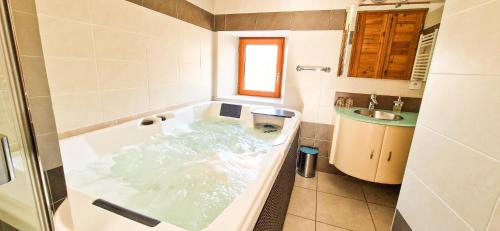 a bathroom with a bath tub and a sink at Les Clarines Perceneige - Chambre d'Hôtes Vue Sur Montagne in Saint-Jacques-en-Valgodemard