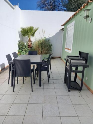 a patio with a table and chairs and a grill at La Ciotat Le Saint Estève in La Ciotat