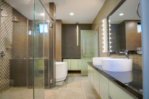 y baño con 2 lavabos, ducha y aseo. en Kuah Town - Villa Indah, en Kuah