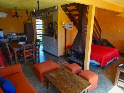 sala de estar con chimenea y mesa en Casa Amarilla con Jacuzzi, en Punta del Diablo