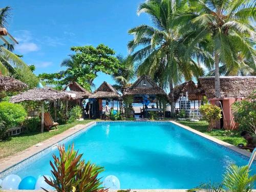 una piscina di fronte a un resort con palme di Piscine bimoko a Nosy Be