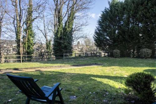 a blue chair sitting in the grass in a yard at Le meilleur des Belles Rives Immozen46 in Argentat
