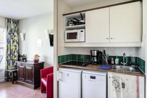 a kitchen with a sink and a microwave at Le meilleur des Belles Rives Immozen46 in Argentat