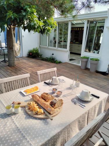 a table with a plate of food on it at Chambre d'hôte ensoleillée à 300m de la plage in La Guérinière