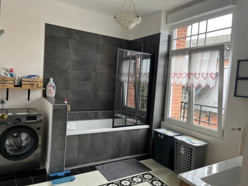 une salle de bain avec baignoire et machine à laver dans l'établissement Maison de maître dans un village à la campagne, à Origny-en-Thiérache