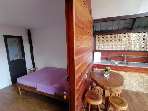 een kleine kamer met een kleine tafel en een bed bij Banlaw Garden Resort in Puerto Princesa City
