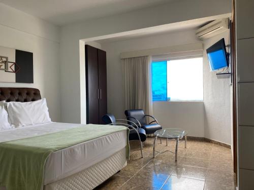 a hotel room with a bed and a tv at Syros Hotel in Gama