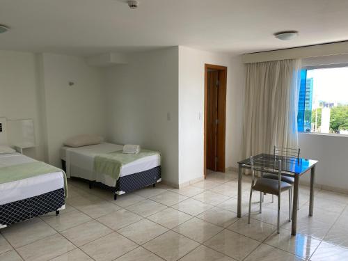 Syros Hotel في Gama: غرفة فندقية بسريرين وطاولة زجاجية