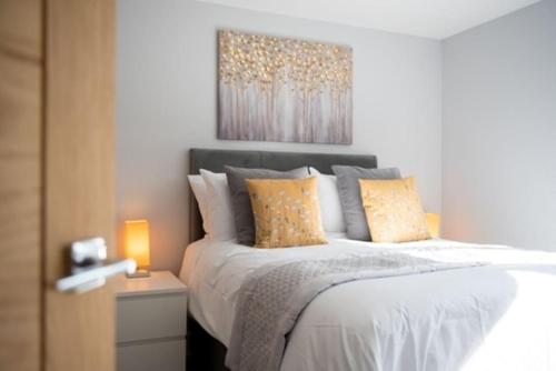 a bedroom with a bed with a painting on the wall at Beautiful, Spacious 1 bed flat in Brentwood