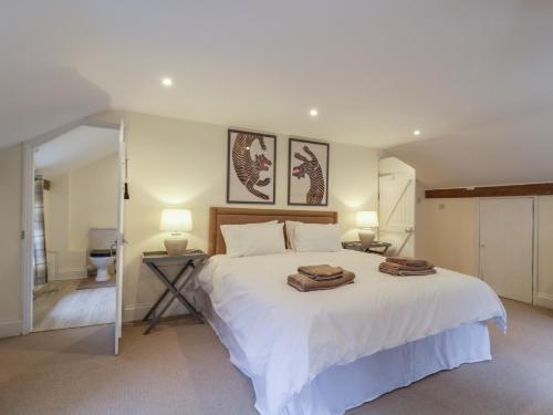 ein Schlafzimmer mit einem weißen Bett mit zwei Handtüchern darauf in der Unterkunft Waldegrave Barn in Hartest