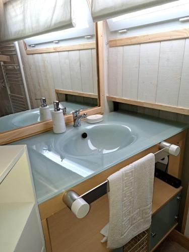 uma casa de banho com um lavatório e um espelho em Yacht, 23 mètres, à quai. em Sète
