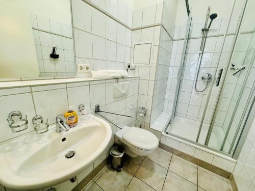 een badkamer met een toilet, een wastafel en een douche bij Traumstrand, am Kurpark in Warnemünde