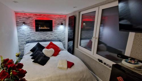 a bedroom with a bed with pillows and a tv at Apartament z Jacuzzi in Kołobrzeg
