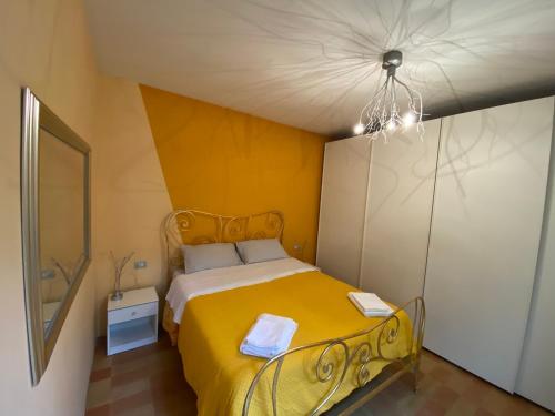 a bedroom with a yellow bed and a mirror at IL NIDO DELLA FORTUNA oasi di pace, relax, storia e mare in Fano