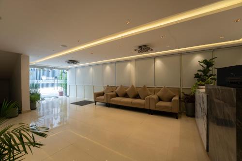 a lobby with a couch in the middle of a room at Sai Bliss International, Bangalore in Bangalore