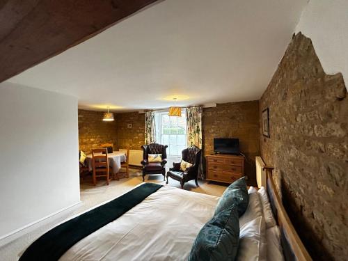 um quarto com uma cama e uma sala de estar em Kingfisher em Lyddington