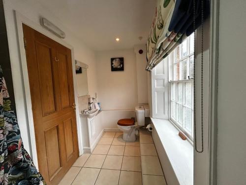 a small bathroom with a toilet and a window at Kingfisher in Lyddington