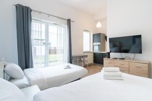 um quarto de hotel com duas camas e uma televisão de ecrã plano em Park Śląski Comfort Studio em Katowice