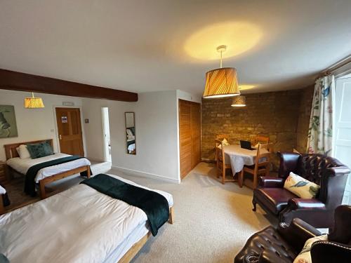 um quarto de hotel com uma cama e uma sala de jantar em Kingfisher em Lyddington
