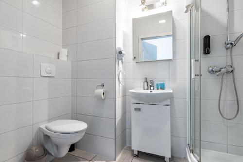 uma casa de banho branca com um WC e um chuveiro em Park Śląski Comfort Studio em Katowice