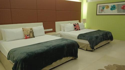 two beds in a hotel room withskirts at Port Dickson Leisure Water Villa in Port Dickson