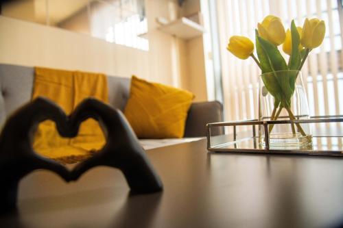 a table with a heart shaped object and flowers on it at Grand Central , 2 double bedroom apartment with free parking , Birmingham in Birmingham