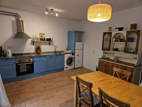 a kitchen with blue cabinets and a wooden table at River Ebro Apartments in Móra d'Ebre