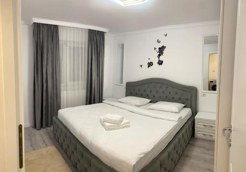 a bedroom with a large bed with white sheets at Apartament Areni Suceava in Suceava