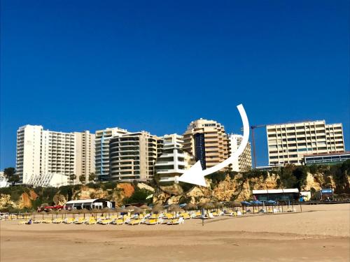 un grupo de sillas en una playa con edificios en Lovely beachfront apartment with Aircon/WIFI, en Portimão