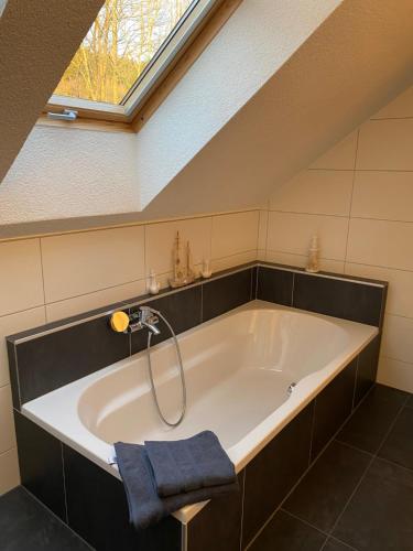 a bathroom with a large bath tub with a skylight at Ferienwohnung Weberschläger in Ulrichsberg