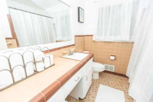 een badkamer met een wastafel, een toilet en een spiegel bij Birmingham Brickstone With Backyard Privacy in Birmingham