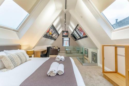 um quarto com uma grande cama branca e chinelos em The Old School House - Luxury Themed Apartments em Nottingham