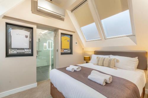 a bedroom with a large bed with two towels on it at The Old School House - Luxury Themed Apartments in Nottingham