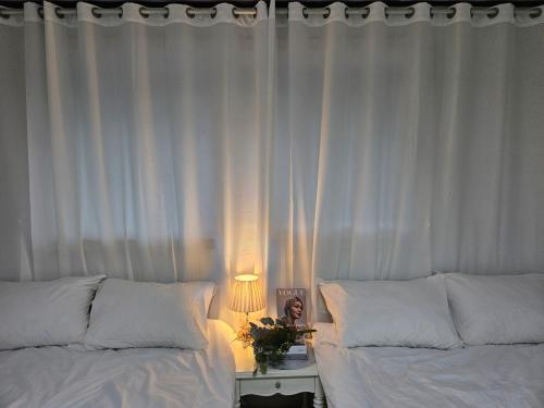 a bedroom with two beds and a table with a lamp at macity in Incheon