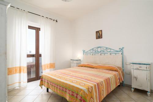 una camera da letto con un letto con una coperta arancione e gialla di Villetta Comfort vicino al Mare a Orosei