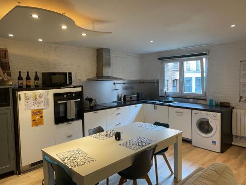 une cuisine avec une table et une table ainsi qu'une cuisine avec dans l'établissement Escalille le Royale, à Lille