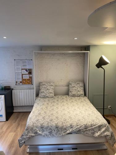 Schlafzimmer mit einem großen Bett mit einem weißen Kopfteil in der Unterkunft Escalille le Royale in Lille