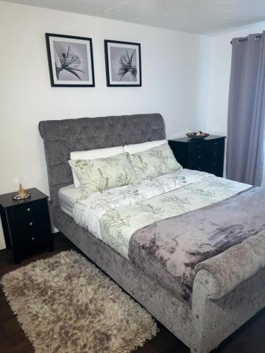 a bedroom with a large bed with two night stands at Frobisher Apartment in Erith