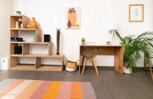 une pièce avec un bureau et une table avec une plante dans l'établissement Le Gustave - Climatisation et cœur de ville, à Montpellier
